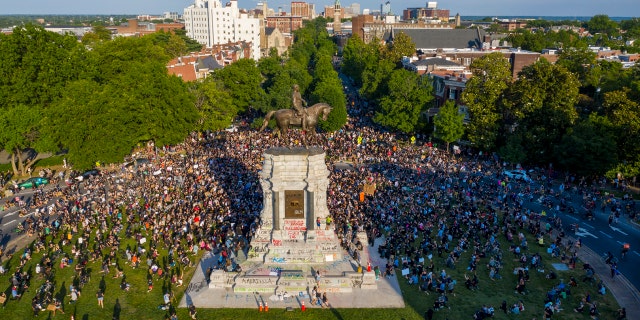 FILE - This Tuesday, June 2, 2020 file photo shows a large group of protesters gather around the statue of Confederate General Robert E. Lee on Monument Avenue near downtown in Richmond, Va. (AP Photo/Steve Helber, File)