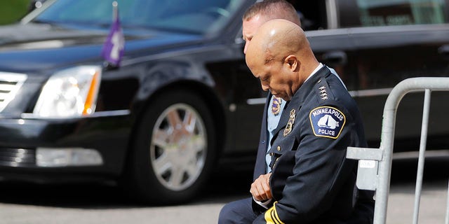 Police officers including Minneapolis Police Chief Medaria Arradondo, foreground, take a knee as the body of George Floyd arrives before his memorial services on Thursday, June 4, 2020 in Minneapolis. (AP Photo/Julio Cortez)