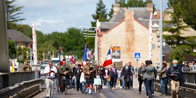 British expatriate Steven Oldrid, left, prepares to film a group crossing over the site of the original WWII Pegasus Bridge during D-Day ceremonies in Benouville, Normandy, France on Saturday, June 6, 2020.
