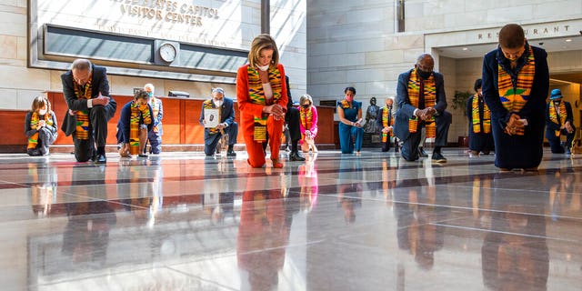 House Speaker Nancy Pelosi of Calif., center, and other members of Congress, kneel and observe a moment of silence at the Capitol's Emancipation Hall, Monday, June 8, 2020, on Capitol Hill in Washington, reading the names of George Floyd and others killed during police interactions. Democrats proposed a sweeping overhaul of police oversight and procedures Monday, an ambitious legislative response to the mass protests denouncing the deaths of black Americans at the hands of law enforcement. (AP Photo/Manuel Balce Ceneta)