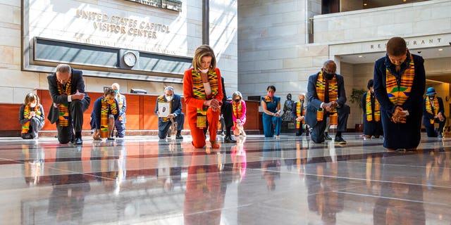 House Speaker Nancy Pelosi of Calif., center, and other members of Congress, kneel and observe a moment of silence at the Capitol's Emancipation Hall, Monday, June 8, 2020, on Capitol Hill in Washington, reading the names of George Floyd and others killed during police interactions. Democrats proposed a sweeping overhaul of police oversight and procedures Monday, an ambitious legislative response to the mass protests denouncing the deaths of black Americans at the hands of law enforcement. (AP Photo/Manuel Balce Ceneta)