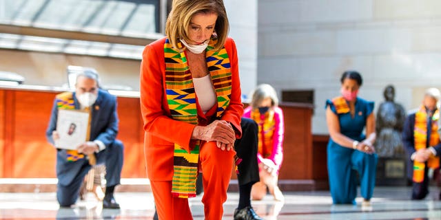 House Speaker Nancy Pelosi of Calif., center, and other members of Congress, kneel and observe a moment of silence at the Capitol's Emancipation Hall, Monday, June 8, 2020, on Capitol Hill in Washington, reading the names of George Floyd and others killed during police interactions. (AP Photo/Manuel Balce Ceneta)