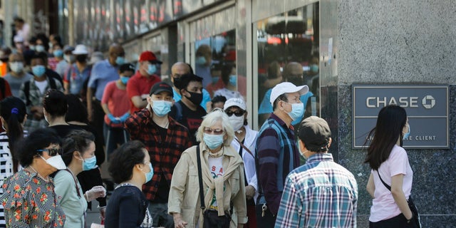 People wear protective masks outside a bank in the Queens borough of New York City, June 8, 2020. (Associated Press)