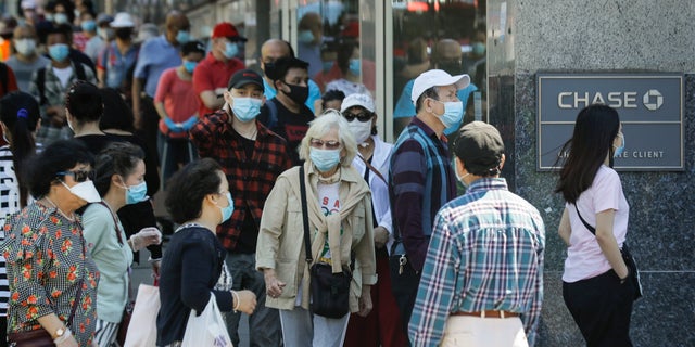 People wear protective masks outside a bank in the Queens borough of New York City, June 8, 2020. (Associated Press)