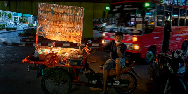 A mobile food vender looks for customers in Bangkok, Thailand, Tuesday, June 9, 2020.