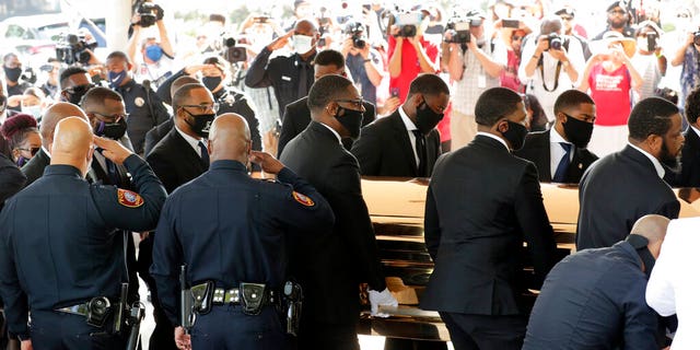 Texas Southern University police salute as family and guests arrive for George Floyd's funeral service at The Fountain of Praise Church on Tuesday, June 9, 2020, in Houston. (AP Photo/Eric Gay)