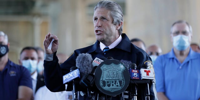 Surrounded by law enforcement and supporters, New York City PBA President Pat Lynch, center, speaks during a news conference in New York, Tuesday, June 9, 2020. (AP Photo/Seth Wenig)
