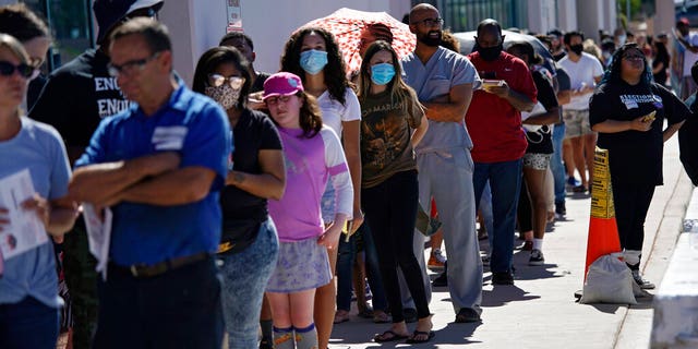 People wait in line at one of a few in person voting places during a nearly all-mail primary election Tuesday, June 9, 2020, in Las Vegas. (AP Photo/John Locher)