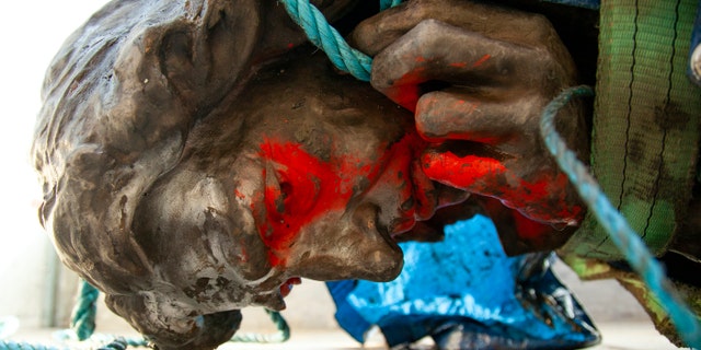 In this photograph made available by Bristol City Council, the statue of Edward Colston is placed in the back of a truck after being recovered from the harbour in Bristol, Thursday June 11, 2020, after it was toppled by anti-racism protesters on Sunday. (Bristol City Council via AP)