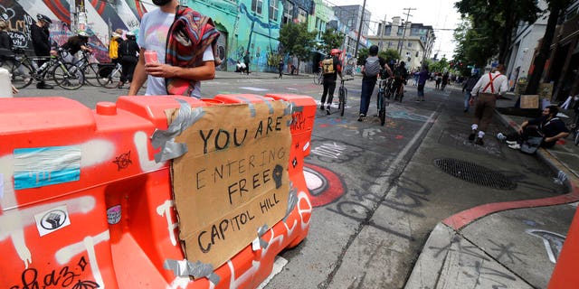 People walk near a sign that reads 