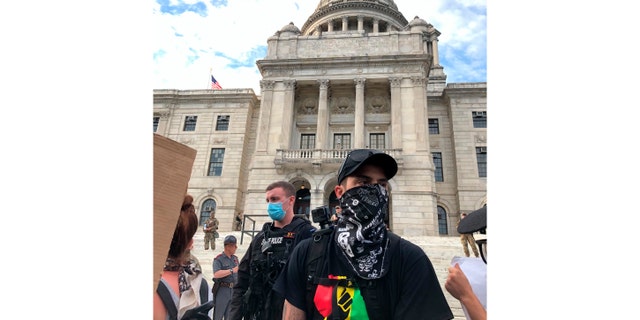 Protesters attend a rally outside the statehouse in Providence, R.I., on June 5, 2020. The smallest U.S. state has the longest name, and it's not sitting well for some in the George Floyd era. Officially, Rhode Island was incorporated as 