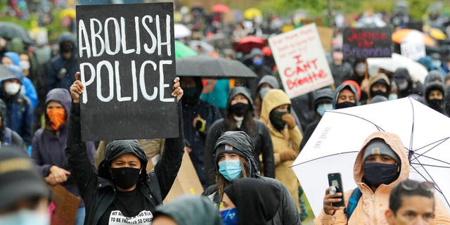 A protester holds a sign that reads "Abolish Police" during a march against racial injustice and police brutality that was organized by Black Lives Matter Seattle-King County, Friday, June 12, 2020, in Seattle.