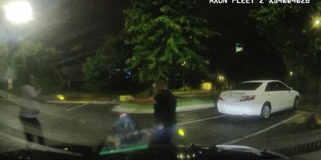 Dashboard camera video provided by the Atlanta Police Department shows Rayshard Brooks, left, and Officer Garrett Rolfe pointing Tasers at one another, while Officer Devin Brosnan is seen getting up after a struggle among the three men in the parking lot of a Wendy's restaurant.