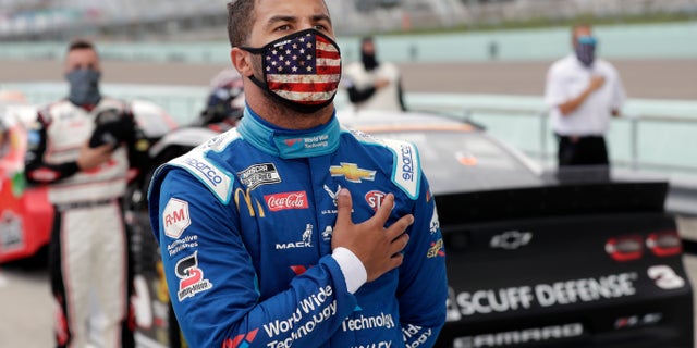 Bubba Wallace stands for the national anthem before a NASCAR Cup Series auto race Sunday, June 14, 2020, in Homestead, Fla. (AP Photo/Wilfredo Lee)