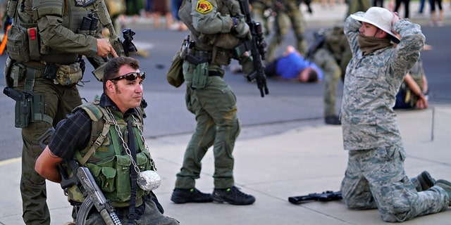 Albuquerque police detain members of the New Mexico Civil Guard, an armed civilian group, following the shooting of a man during a protest over a statue of Spanish conquerer Juan de Oñate on Monday, June 15, 2020, in Albuquerque, N.M. (Adolphe Pierre-Louis/The Albuquerque Journal via AP)