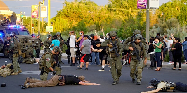 Albuquerque police detain members of the New Mexico Civil Guard, an armed civilian group, Monday, June 15, 2020, in Albuquerque, N.M.  (Adolphe Pierre-Louis/The Albuquerque Journal via AP)