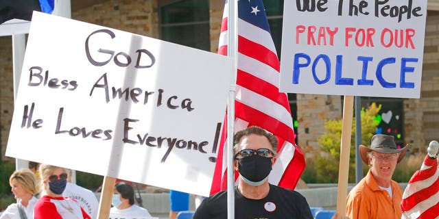 In this Monday, June 15, 2020, photo, people gather to publicly express support of local police, in Cottonwood Heights, Utah.