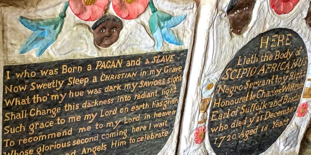 Casts of the headstone and footstone of an enslaved African man, in the entrance to St Mary's church. The Grade II-listed, brightly painted memorial to Scipio Africanus have been smashed and a message was scrawled in chalk on flagstones nearby. (Ben Birchall/PA via AP)