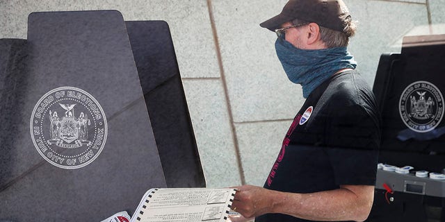 A voter casts a ballot at a polling station inside the Brooklyn Museum in New York in June 2020. [AP Photo/John Minchillo, File)