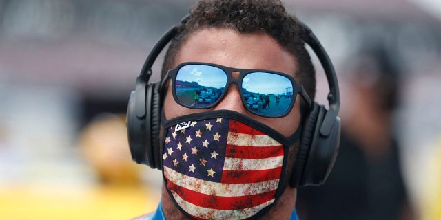 Driver Bubba Wallace walks to his car in the pits of the Talladega Superspeedway prior to the start of the NASCAR Cup Series auto race at the Talladega Superspeedway in Talladega Ala. (AP Photo/John Bazemore)