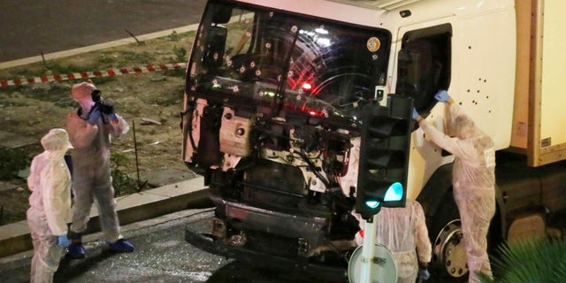 Authorities investigate a truck after it plowed through Bastille Day revellers in the French resort city of Nice, southern France, on July 14, 2016. France's counterterrorism prosecutors have requested nine suspects to be sent to trial in connection with the attack in Nice that left 86 people dead.<br>
(Sasha Goldsmith via AP, File)