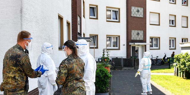 Medical staff and helpers from the German army take COVID-19 tests of Toennies employees and their families who are quarantined in Verl, Germany, Tuesday, June 23, 2020. Following the corona outbreak at meat processor Toennies in Rheda-Wiedenbrueck, the federal state authorities are massively restricting public life in the Guetersloh district with a lockdown.
