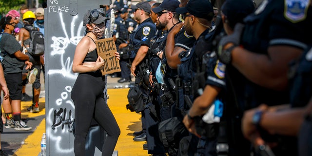 A woman holds up a sign saying 