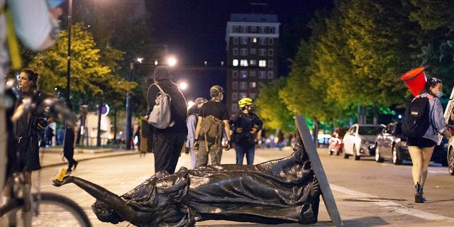 Wisconsin's "Forward" statue lies in the street on Capitol Square in Madison on Tuesday. The statue has since been recovered, officials said. (Emily Hamer/Wisconsin State Journal via AP)