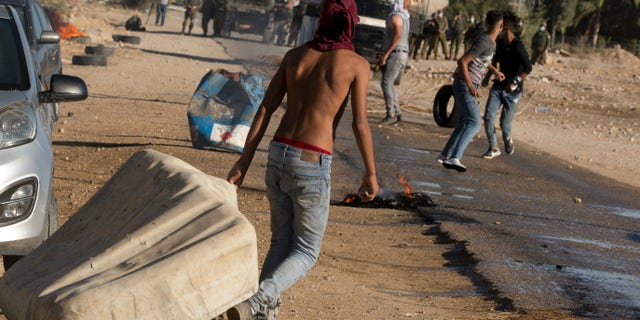 Palestinian demonstrators clash with the Israeli troops during a protest against Israel's plan to annex parts of the West Bank and Trump's Middle East initiative, at the village of Fasayil, in Jordan Valley, Wednesday, Jun. 24, 2020. (AP Photo/Majdi Mohammed)