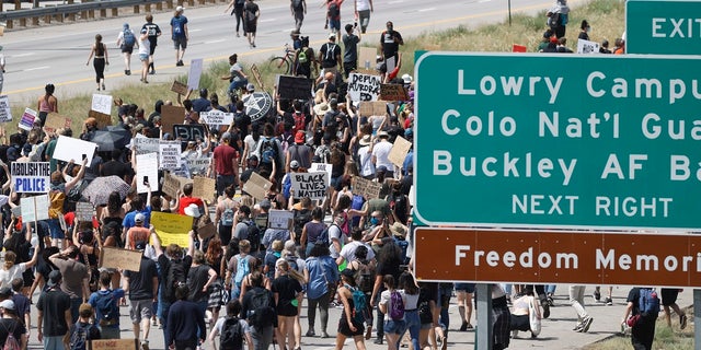 Demonstrators step on to Interstate 225 to block traffic during a rally and march over the death of 23-year-old Elijah McClain in Aurora, Colo. (AP Photo/David Zalubowski)