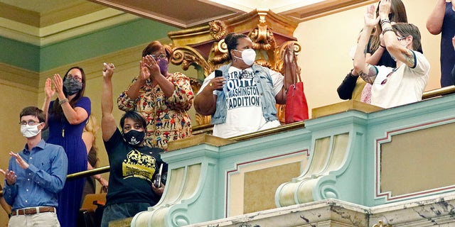 Members of the Mississippi Senate gallery rise and applaud after the body passed a resolution that would suspend the rules to allow lawmakers to change the state flag, Saturday, June 27, 2020 at the Capitol in Jackson, Miss. (Associated Press)
