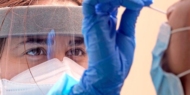 Medical student Kimberly Olivares, left, takes a sample from a patient at a free COVID-19 testing site provided by United Memorial Medical Center, Sunday, June 28, 2020, at the Mexican Consulate, in Houston. Confirmed cases of the coronavirus in Texas continue to surge. On Friday, Texas Gov. Greg Abbott shut down bars again and scaled back restaurant dining as cases climbed to record levels after the state embarked on one of America's fastest reopenings.