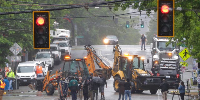 Seattle Department of Transportation workers remove barricades at the intersection of 10th Ave. and Pine St. on Tuesday at the CHOP zone in Seattle. Protesters quickly moved couches, trash cans and other materials in to replace the cleared barricades. (AP Photo/Ted S. Warren)