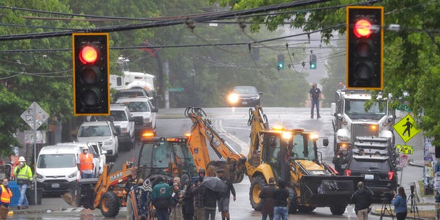 Seattle Department of Transportation workers remove barricades at the intersection of 10th Ave. and Pine St. on Tuesday at the CHOP zone in Seattle. Protesters quickly moved couches, trash cans and other materials in to replace the cleared barricades. (AP Photo/Ted S. Warren)