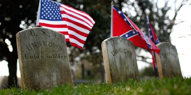 The graves of a Union soldier with Confederate soldiers are shown at the Appomattox Court House National Historical Park April 7, 2015, in Virginia. 