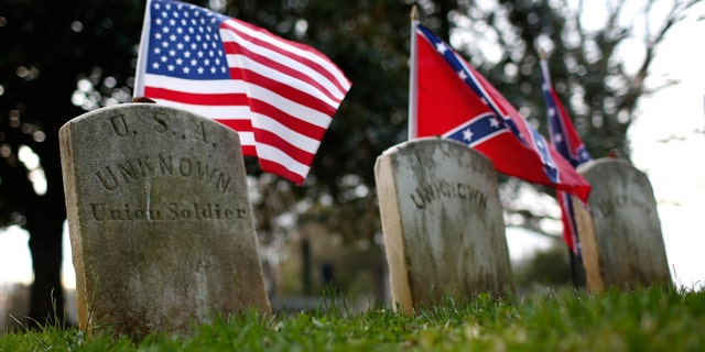 The graves of a Union soldier with Confederate soldiers are shown at the Appomattox Court House National Historical Park April 7, 2015, in Virginia. 