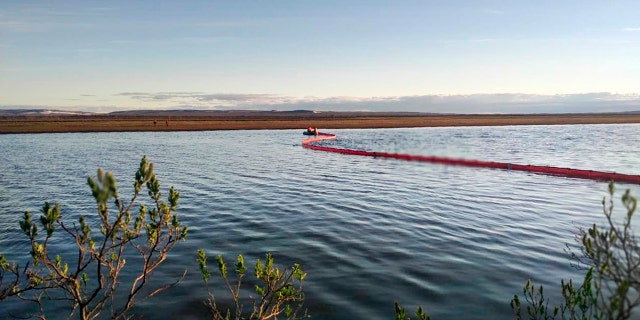 In this handout file photo dated June 2, provided by the Russian Marine Rescue Service, rescuers work to prevent the spread from an oil spill outside Norilsk, 1,800 miles northeast of Moscow, Russia.