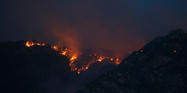 The Bighorn Fire moves along the western side of the Santa Catalina Mountains, Sunday, June 14, 2020, in Oro Valley, Ariz.
