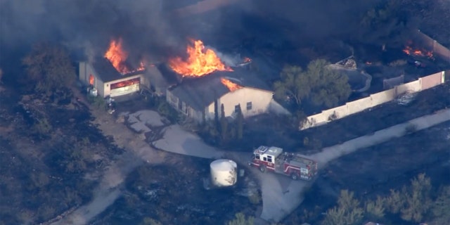 A home burns as the Aquila Fire rapidly spread through a north Phoenix neighborhood on Tuesday.