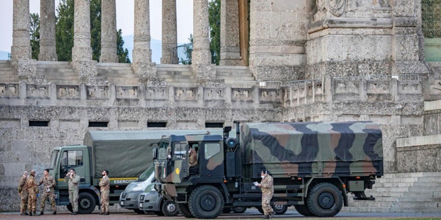 Italian military trucks and soldiers are seen by Bergamo's cemetery after the army was deployed to move coffins from the cemetery to neighboring provinces, after the cemetery was overwhelmed by the scale of the coronavirus disease (COVID-19) outbreak, in Bergamo, Italy, March 18. Sergio Agazzi.Fotogramma via REUTERS