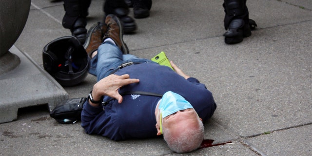 Martin Gugino, a 75-year-old protester, lays on the ground after he was shoved by two Buffalo, New York, police officers