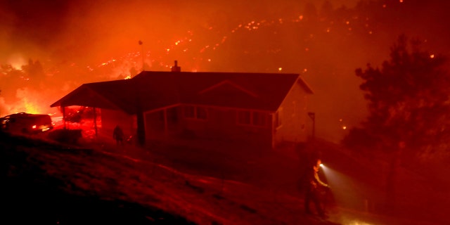 Firefighters protect homes as a wildfire burns in Solano County near Winters, Calif., early June 7.