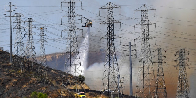 A firefighting aircraft drops water on the Elizabeth Fire, June 10, near Santa Paula, Calif.