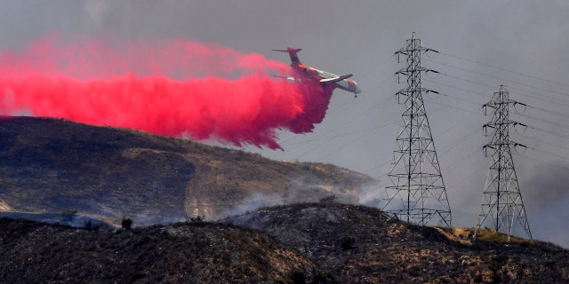 A firefighting DC-10 Air Tanker drops fire retardant on the Elizabeth Fire, Wednesday, June 10, 2020, near Santa Paula, Calif.