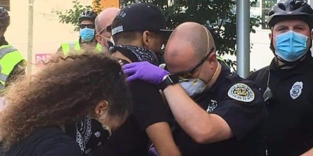 Nashville, Tenn. Officer Garren Hoskins prayed with a protester Saturday, May 30, 2020 during a peaceful protest.