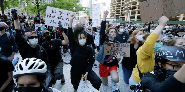 People get down on their knee during a protest over the death of George Floyd in Chicago, Saturday, May 30, 2020. Protests were held throughout the country over the death of Floyd, a black man who died after being restrained by Minneapolis police officers on May 25. (AP Photo/Nam Y. Huh)