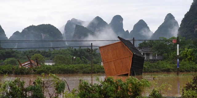 In this June 7, 2020, photo released by Xinhua News Agency, facilities at a tourism site are toppled in the aftermath of a flood after heavy downpour in Yangshuo of Guilin, south China's Guangxi Zhuang Autonomous Region.