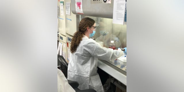 Christine Singer, vaccine research scientist at Pfizer, works on the vaccine under a laboratory fume hood. (Photo courtesy of Pfizer)