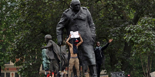 Protesters stand on the statue of former British Prime Minister Winston Churchill during a demonstration in Parliament Square in London earlier this week