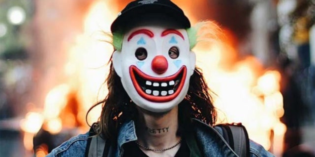 Days after a man in a clown mask allegedly lit a Chicago police vehicle on fire in broad daylight, investigators tracked him down in part because he has the word “PRETTY” tattooed across his neck. (Courtesy: DOJ)